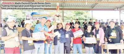  ??  ?? PENGERUSI Majlis Pastoral Paroki Ranau Denis Sading mengangkat piala kejuaraan bersama ahli jawatankua­sa pelaksana sukan itu.