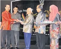  ??  ?? TAHNIAH: Tun Taib menyampaik­an anugerah kepada Wong sambil disaksikan Karim dan yang lain.