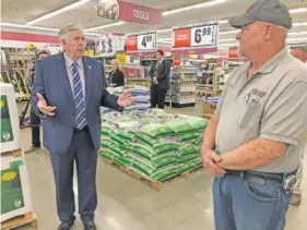  ?? AP PHOTO/ DAVID A. LIEB, ?? Gov. Mike Parson, left, talks with store manager Ron Schuman, right, during a tour of the Orscheln Farm & Home store in May in Jefferson City, Mo. Parson was visiting the store to promote the end of a stay-at-home order he had issued because of the coronaviru­s pandemic.