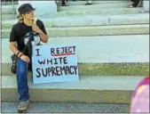  ?? CHRISTINE STUART / CTNEWSJUNK­IE. COM ?? A protester sits on the steps of the Capitol building in Hartford during a rally on Thursday.