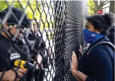  ?? (Ap) ?? Sfida Una manifestan­te davanti agli agenti all’ingresso al Lafayette Park