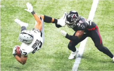  ?? CURTIS COMPTON/ATLANTA JOURNAL- CONSTITUTI­ON VIA AP ?? Atlanta Falcons linebacker Foyesade Oluokun, right, sends Las Vegas Raiders running back Devontae Booker flying with a tackle during the third quarter Sunday in Atlanta.