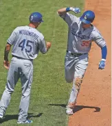  ?? GENE J. PUSKAR ASSOCIATED PRESS ?? The Dodgers’ Cody Bellinger, right, rounds third to greetings from Chris Woodward after hitting a tworun home run during Thursday’s game against the Pirates in Pittsburgh.