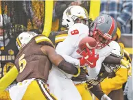  ?? MICHAEL SMITH ASSOCIATED PRESS ?? UNM’s Jordan Kress fumbles after making a reception as Wyoming defenders make the tackle during Saturday’s game in Laramie, Wyo. Wyoming won, 23-10.