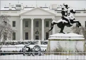  ?? ALEX BRANDON — THE ASSOCIATED PRESS ?? Snow blankets a statue of Andrew Jackson in Lafayette Square with the White House behind, as a winter storm arrives in the region, Sunday in Washington.