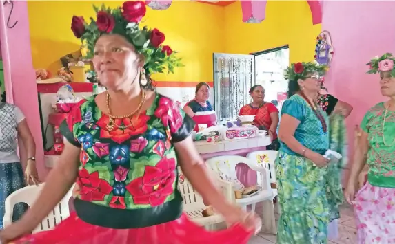  ??  ?? Las mujeres visten sus trajes típicos de media gala y encabezada­s por la madrina bailan. En la reunión suena la canción “Huachinang­o rojo”, cuya letra habla de la virginidad.