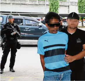  ??  ?? In custody: One of the suspected militants detained in Ranau, Sabah.