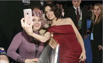  ?? THE ASSOCIATED PRESS ?? Daisy Ridley, right, takes a selfie with a fan as she arrives at the world premiere of “Star Wars: The Rise of Skywalker.”