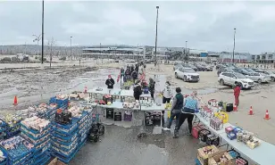  ?? THE CANADIAN PRESS ?? Residents affected by flooding line up as the Wood Buffalo Food Bank Associatio­n gives away produce donated by Superstore in Fort McMurray, Alta., on Saturday.