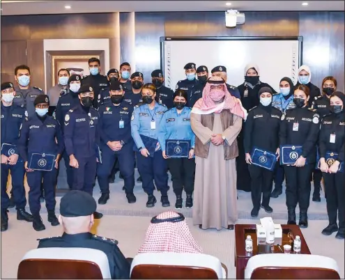  ?? KUNA photo ?? The Minister of Interior Sheikh Thamer Ali Sabah Al-Salem Al-Sabah poses for a picture with trainees for the course for deaf and dumb at the Specialize­d Training Center for Ports Security Affairs.