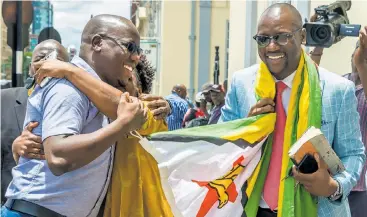  ?? Picture AFP ?? Zimbabwe cleric Pastor Evan Mawarire, an opponent of Robert Mugabe, right, celebrates with his supporters last month outside the High Court in Harare where he was acquitted of all charges against him, including trying to overthrow the government.