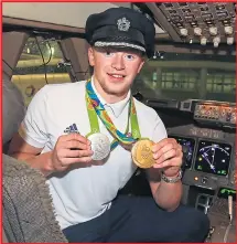  ??  ?? Swimmer Adam Peaty shows off his medals in the cockpit