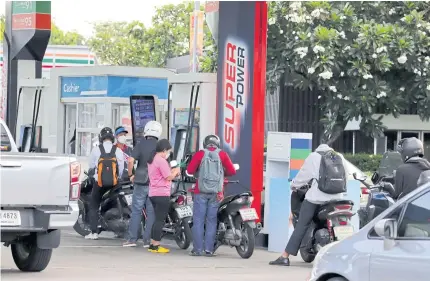  ?? CHANAT KATANYU ?? Motorcycle­s refuel at a petrol station. Mr Arkhom says the status of the Oil Fuel Fund improved as global crude oil prices drop, in parallel with the ministry’s excise tax cut.