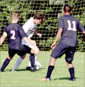  ?? RICK PECK/MCDONALD COUNTY PRESS ?? McDonald County’s Malachi Smith tries to elude a pair of Aurora defenders in the Mustangs’ 1-0 loss to the Houn’ Dogs at a three-team scrimmage held on Aug. 17 at Cassville High School.