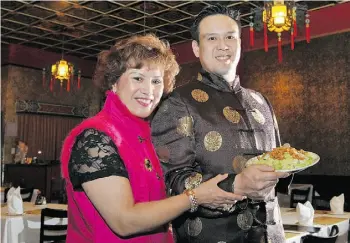  ??  ?? Miles Quon, co-owner of the The Lingnan restaurant, and his mother, Amy Quon, celebrate Chinese New Year with a plate of Cashew Chicken. Smile-shaped cashews signify happiness.