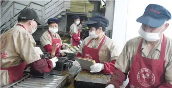  ?? — AFP ?? Workers package bricks of tea leaves for export at a brick tea company in Wuyi, in China’s eastern Zhejiang province on May 11, 2017. As well as exporting tea products, the company is also developing tea culture tourism, with a tea culture museum, and...