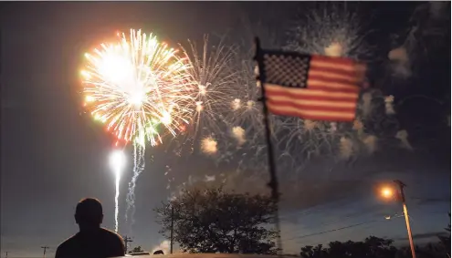  ?? Christian Abraham / Hearst Connecticu­t Media file photos ?? Above and at left, spectators watch the fireworks display at Short Beach in Stratford in July 2013. The show is to return on Thursday.