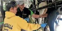  ??  ?? Year 10 student Rachel Joseph from Flaxmere College has a closer look at putting cups on a cow with help from BEL Group’s Robert Barry at the Dairy Day Out in Central Hawke’s Bay.