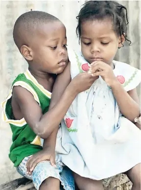  ?? FILE ?? In this 1998 photograph, four-year-old Dean Smikle shares a biscuit with two-year-old Chinel Cunningham, a perfect example of what it means to give to others.