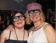  ??  ?? MaryGrace Fedoris and Missie Souders try out Photo Booth props during Night to Shine on Feb. 10.