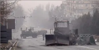  ?? ?? Servicemen and their military vehicles block a street in central Almaty after violence that erupted following protests over hikes in fuel prices.