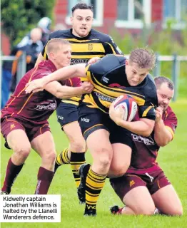  ??  ?? Kidwelly captain Jonathan Williams is halted by the Llanelli Wanderers defence.