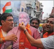  ?? REUTERS ?? People hold a cut-out of Prime Minister Narendra Modi as they celebrate after the government scrapped the special status of Kashmir, in Ahmedabad, on 5 August.