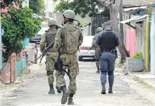  ?? GLADSTONE TAYLOR ?? Members of the Jamaica Defence Force and the Jamaica Constabula­ry Force patrol the streets of Denham Town, the second declared zone of special operations, back in October.