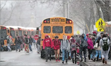  ?? SEAN D. ELLIOT/THE DAY ?? Norwich Free Academy students make their way to the school buses in the midst of a snow squall as classes dismiss early ahead of a nor’easter on Wednesday. Snow showers during the day were expected to intensify into the evening with heavy snow forecast...