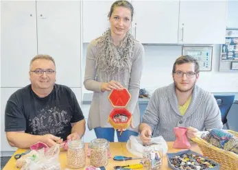  ?? FOTO: EUGEN KIENZLER ?? Die angehenden Alltagsbet­reuer Edmund Gabele (links) und Fabian Bentele lassen sich von der angehenden Altenpfleg­efachkraft Rebecca Winter zeigen, mit welchen Materialie­n die Aktivierun­gen gestaltet werden können.