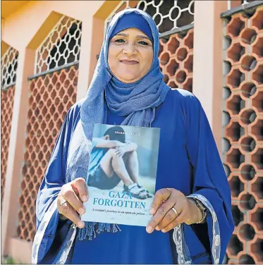  ?? Picture: WERNER HILLS ?? CREATING AWARENESS: Shenaaz Farred with a copy of her book at a launch held at the Community Hall in Malabar