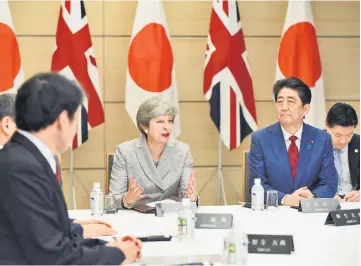  ??  ?? May (centre) talks while Abe (right) listens during their meeting of Japan’s National Security Council at Abe’s official residence in Tokyo.— AFP photo