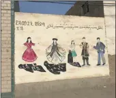  ??  ?? A mural on the walls of a village near Korla, Xinjiang, shows women bursting out of dark veils into colorful clothing. Another mural that minders obstructed the Los Angeles Times from photograph­ing showed a large ax chopping Uighurs holding a flag associated with the region’s independen­ce into pieces.