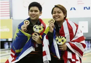  ??  ?? Deadly duo: National bowlers Rafiq Ismail and Shalin Zulkifli posing with their Masters gold medals at the Sunway Mega Lanes during the KL SEA Games last month.