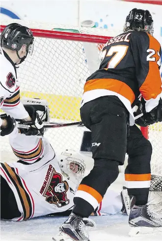  ?? RYAN MCLEOD ?? Trevor Martin can’t keep the puck out of the net as Medicine Hat Tigers forward Mark Rassell stuffs it into the net for one of his three goals on the night in a 7-2 Tigers triumph Friday at Scotiabank Saddledome. It was a costly loss for the Hitmen,...