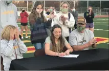  ?? SHARON MARTIN — ENTERPRISE-RECORD ?? Chico High’s Candice Wainschel, seated center, signs her letter of intent to play field hockey for Adelphi University in New York on Friday at Chico High’s Panther Stadium. Wainschel’s parents, Jonie Meyer, left, and Larry Wainschel, right, applaud in support.