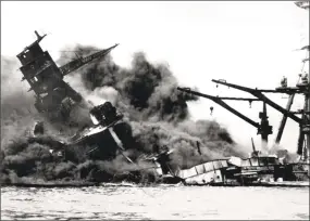  ?? Associated Press file photos ?? The battleship USS Arizona belches smoke as it topples over into the sea during a Japanese surprise attack on Pearl Harbor, Hawaii, on Dec. 7, 1941.