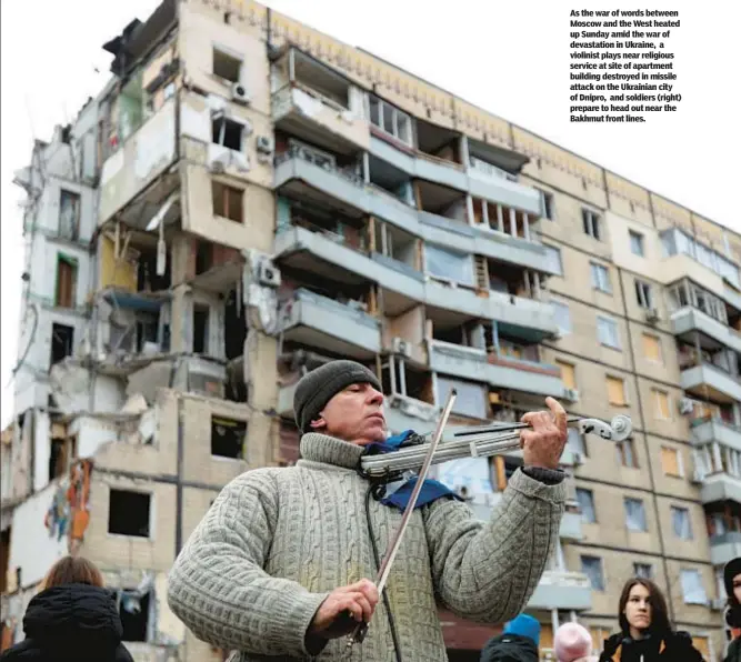  ?? ?? As the war of words between Moscow and the West heated up Sunday amid the war of devastatio­n in Ukraine, a violinist plays near religious service at site of apartment building destroyed in missile attack on the Ukrainian city of Dnipro, and soldiers (right) prepare to head out near the Bakhmut front lines.