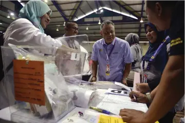  ??  ?? Othman (centre) in a light moment with EC personnel after the handing over of ballot boxes to the election workers handling the Sungai Kandis state by-election. — Bernama photo