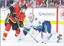  ??  ?? Johnny Gaudreau #13 of the Calgary Flames takes a shot on Jacob Markstrom #25 of the Vancouver Canucks during an NHL game at Scotiabank­Saddledome on Nov 7 in Calgary, Alberta, Canada. (AFP)