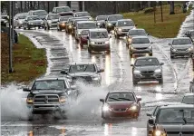  ?? JOHN SPINK / JSPINK@AJC.COM ?? Motorists navigate pooling water Thursday on the Camp Creek Parkway exit from southbound I-85 near Hartsfield-Jackson Internatio­nal Airport. Georgia Power and Georgia EMC said more than 20,000 customers lost power.