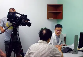  ??  ?? A CCTV crew films Gu as he treats a patient in his clinic. It’s for a documentar­y on the family doctor program.