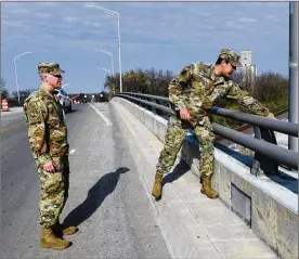  ?? U.S. AIR FORCE PHOTO BY TY GREENLEES ?? U.S. Air Force Senior Master Sgt. David Briden (left) and Tech. Sgt. Anthony Staton stand on the South Maple Avenue bridge in Fairborn on Nov. 20. Two days earlier, these Airmen assigned to Wright-Patterson Air Force Base stopped to aid a teen who was hanging over the side of the bridge and appeared to be in distress. They stayed with the teen until police and medics arrived.