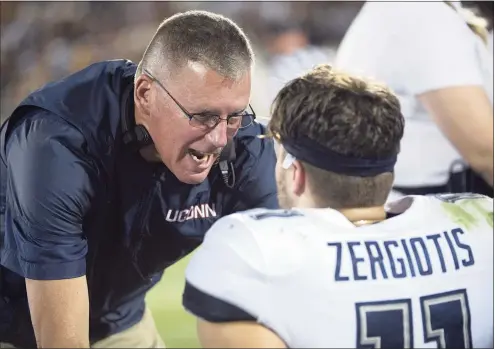  ?? Phelan M. Ebenhack / Associated Press ?? UConn coach Randy Edsall, left, talks to quarterbac­k Jack Zergiotis on the bench during the first half against Central Florida in 2019.