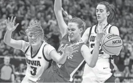  ?? MATT KROHN/USA TODAY SPORTS ?? Iowa’s Sydney Affolter (3) and Caitlin Clark, right, get tangled up with Nebraska’s Natalie Potts during Sunday’s hard-fought Hawkeye victory in the Big Ten Tournament final.