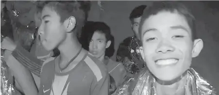  ??  ?? Trapped young soccer players, helped by Thai navy SEALs, inside a cave in Mae Sai, Thailand. Top, Thai rescue teams use headlamps to navigate a narrow, pitch-black segment of the cave complex.