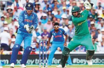  ?? AP ?? Pakistan Shoaib Malek plays a backfoot drive as India’s wicketkeep­er Mahendra Singh Dhoni watches during the Champions Trophy final at the Oval last year. India-Pakistan matches have always been a fan favourite and they will meet at Old Trafford in...