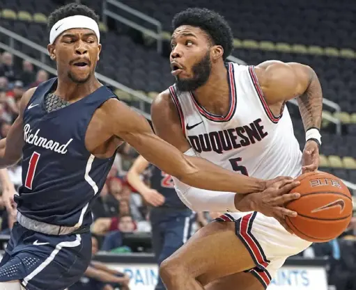  ?? Peter Diana/Post-Gazette ?? Richmond guard Blake Francis steals the ball from Duquesne forward Marcus Weathers Friday at PPG Paints Arena. The Dukes committed 13 turnovers.