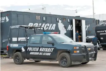  ??  ?? Policías estatales junto a una patrulla y un tráiler de la corporació­n.