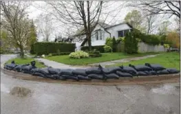  ?? JOHN RENNISON, THE HAMILTON SPECTATOR ?? A sandbag dike has been erected in front of 48 Ravine Dr. in Dundas after a blocked storm drain on Westoby Court sent water cascading out of the neighbourh­ood, across Watsons Lane.